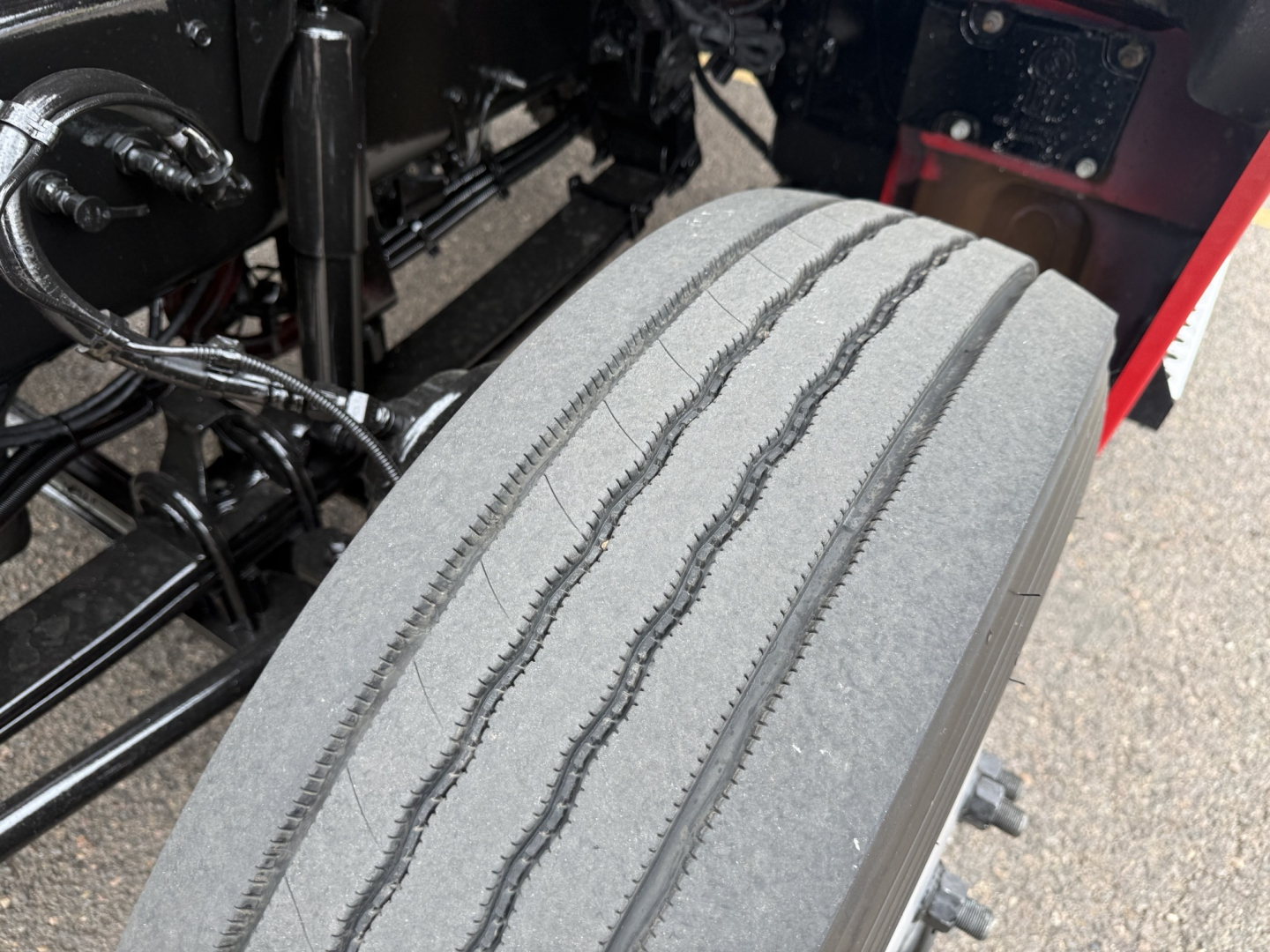 Kenworth T880 wheel and tire in-view showing tread with surrounding chassis and suspension components.