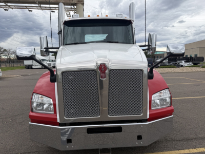 Kenworth T880 front view showing chrome grille, large bumper, dual side mirrors, and red fenders.