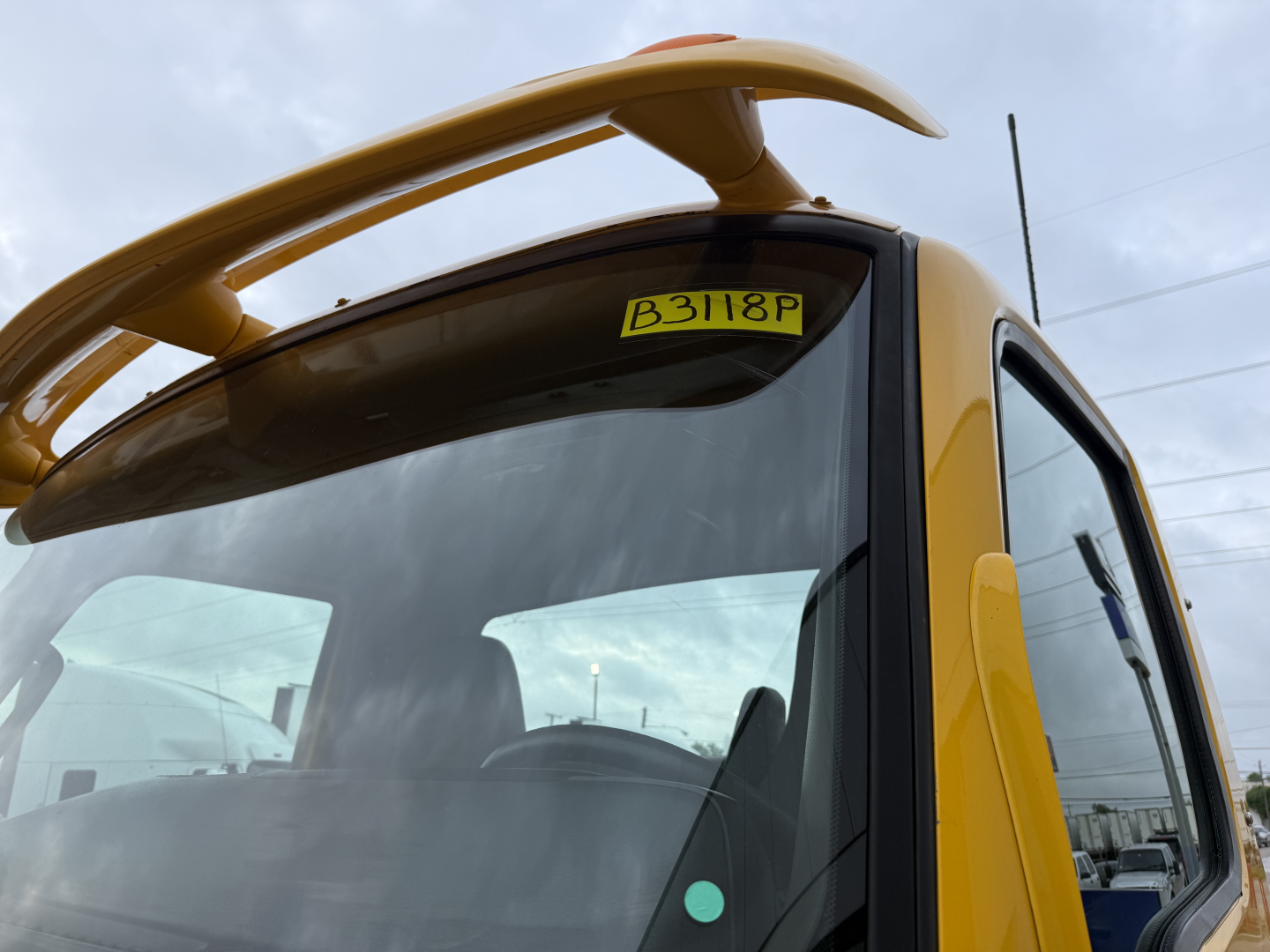 Cab over view of a yellow 2019 International LT truck cab with a sun visor and windshield; visible sticker B3118F on the windshield.