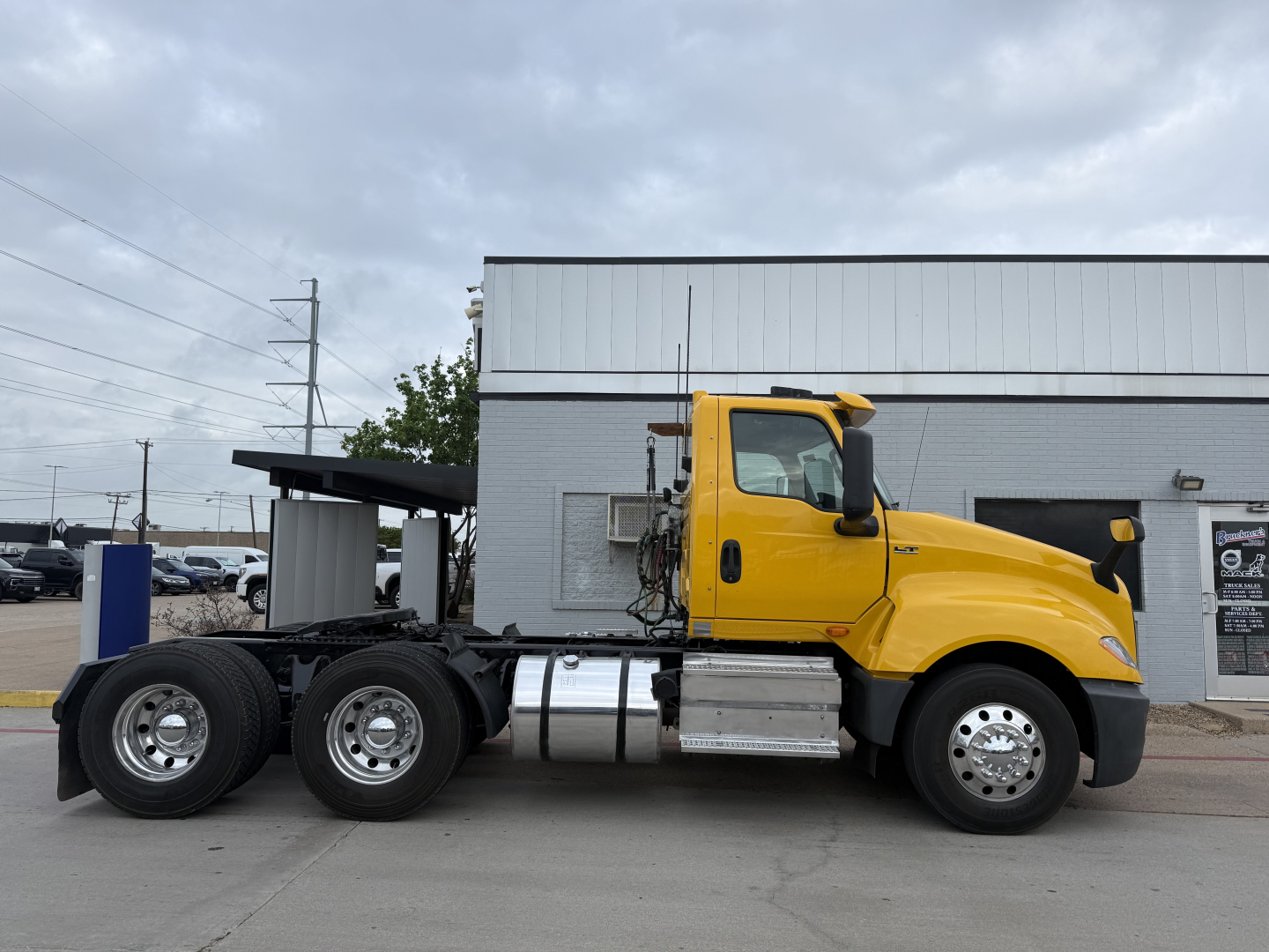 Yellow 2019 International LT conventional daycab tractor truck side view showing cab, fuel tanks, and chassis with dual rear axles.