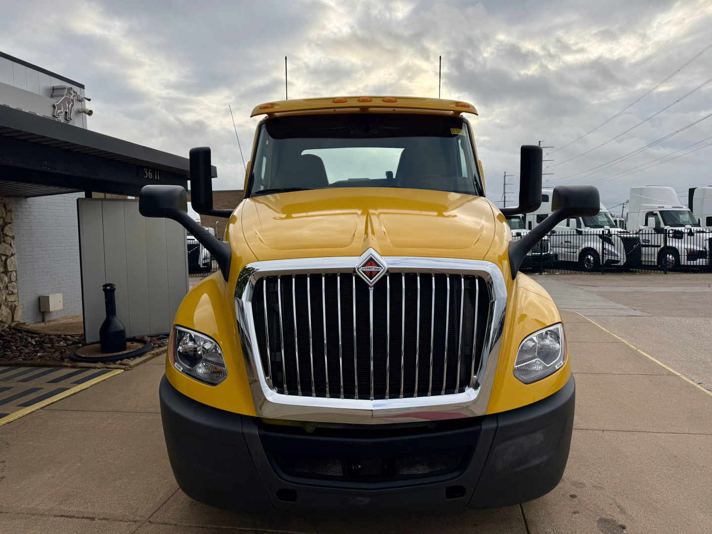 Front view of a yellow 2019 International LT conventional daycab truck with large chrome grille, black bumper, and side mirrors.