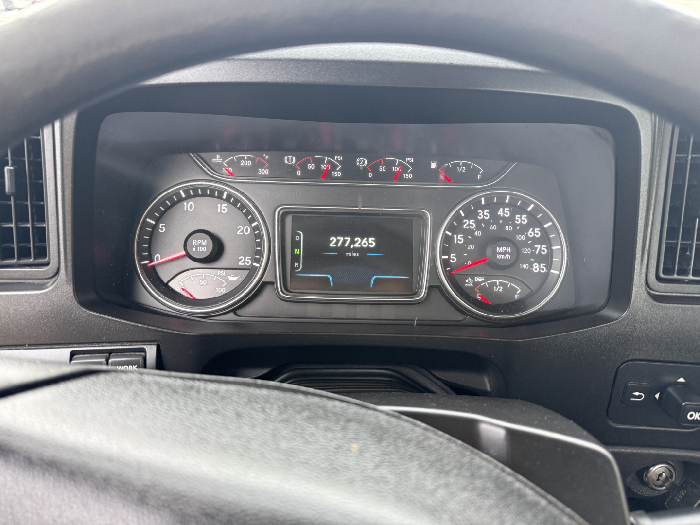 Truck dashboard of a 2019 International LT showing gauges and digital odometer reading 277,265 miles.