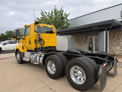 2019 International LT conventional daycab tractor rear view with yellow cab and dual rear axles, chrome fuel tanks, and fifth wheel, truck with stock number B3118P.