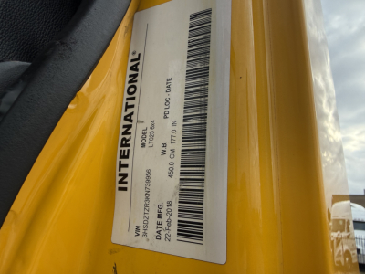 International label on yellow truck door showing model and specs: INTERNATIONAL, J6? 9? VIN 3HSDZTZR3KN739956, model data, barcodes, dates.