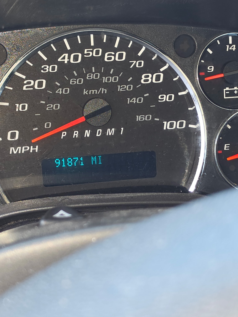 Dashboard of a Chevrolet Express 3500 showing speedometer up to 100 mph, odometer reading 9187 miles, and gear indicator PRNDM1.