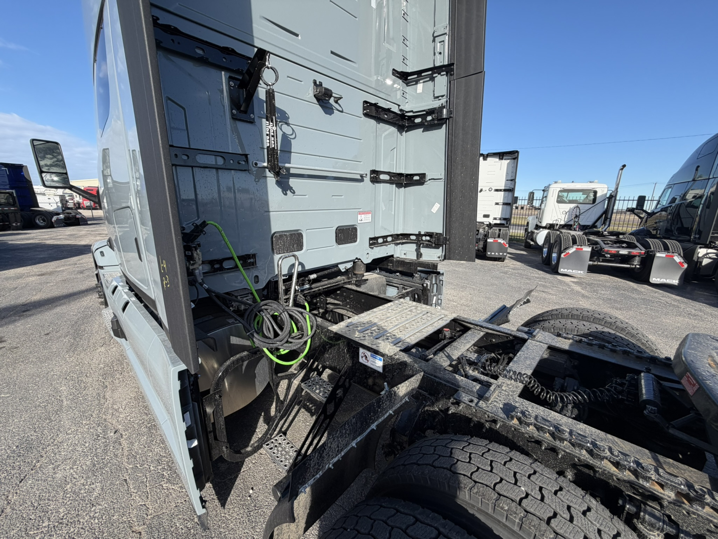 Truck cab and rear chassis of a Mack PR64T76H with fifth wheel and wiring harness visible in the sleeper cab area.