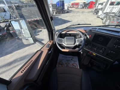 Cabin interior of a 2026 Mack PR64T76H truck showing steering wheel, dashboard, and driver's seat with brown trim.