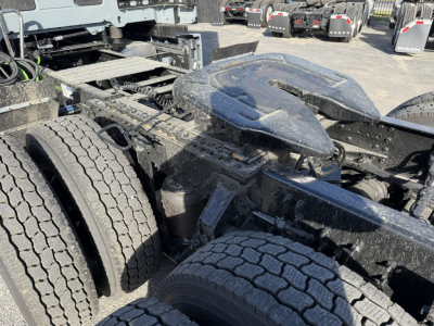 Mack PR64T76H truck chassis showing fifth-wheel air reservoir and dual rear wheels, with heavy-duty frame and components visible.