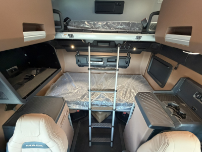 Mack PR64T76H sleeper cab interior showing ladder to upper bunk and side storage compartments.