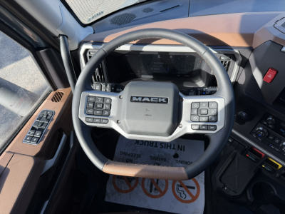 Mack PR64T76H truck interior steering wheel with control buttons and dashboard view.