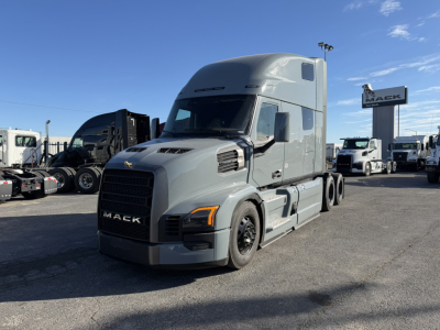 Tractor unit in a dealership lot showing a 2026 Mack PR64T76H sleeper cab truck with gray paint and black grille, side mirrors, and aerodynamic roof fairing.