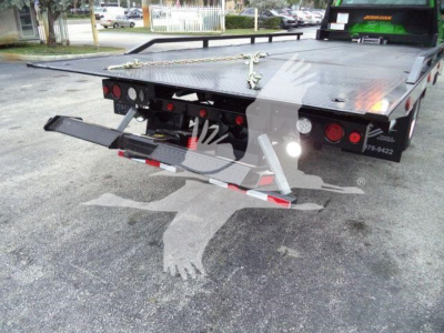 Truck tow bed with rear view showing hydraulic ramps and flatbed surface.