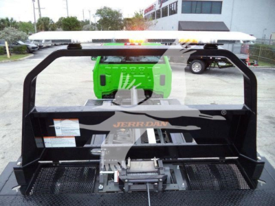 Trucks equipment with a green generator in background and a JERR-DAN rollback bed in foreground showing a winch and mounting hardware.