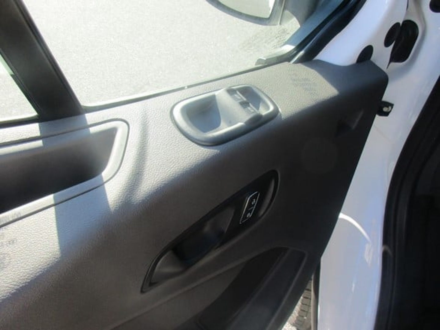 Ford Transit cargo van interior door panel and window switch visible from open driver-side door.