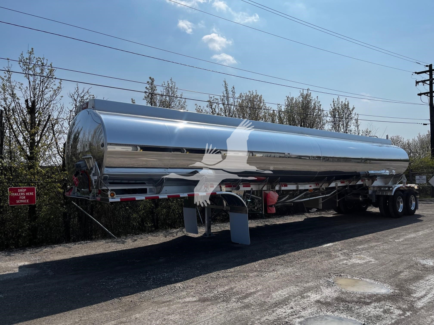 Heil 9500 gallon tanker trailer with polished stainless steel cylindrical tank, dual rear axles, and landing gear visible. VIN/stock not visible on the tank.
