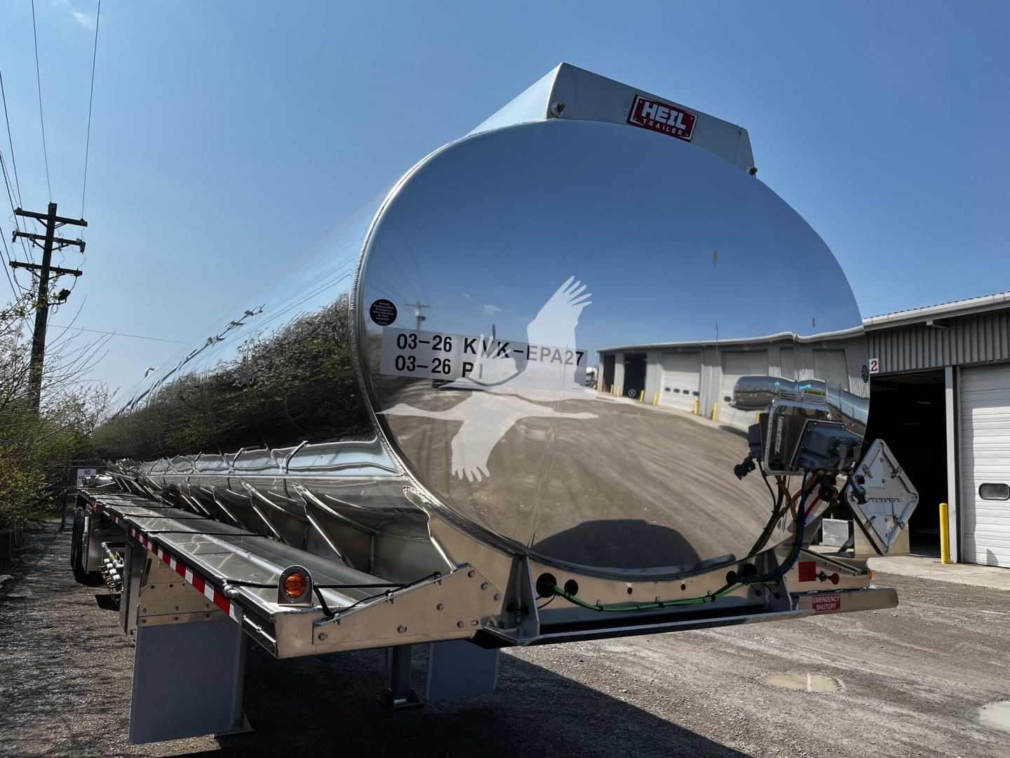 Heil 9500 gallon gasoline trailer tank viewed from rear-left angle showing reflective cylindrical tank and rear bumper supports.