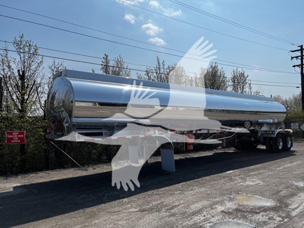 Heil 4-comp tanker trailer in polished stainless steel, side view showing dual-axle chrome wheels and front landing gear, with a watermark overlay.