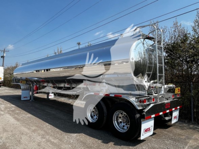 Tank trailer with reflective chrome finish showing rear and side, dual rear tires, ladder, and safety lights. No visible text readable on the tank surface.