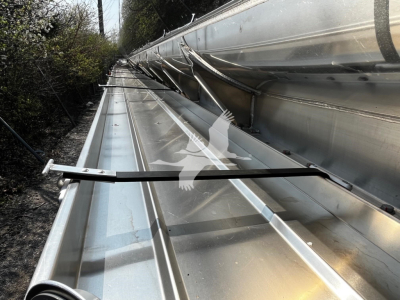 Trailer exterior component showing metal rails and support framing along a long side with reflective aluminum surface.