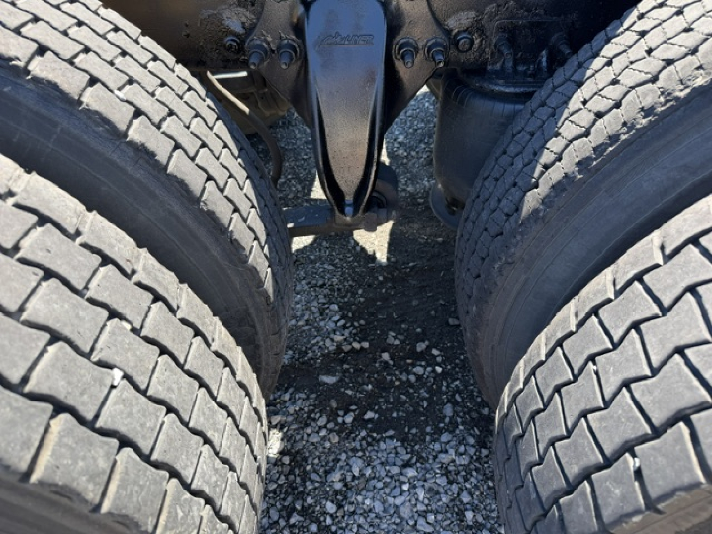 Freightliner Cascadia CA125DC drivetrain with dual rear dual tires and suspension components visible between wheels.