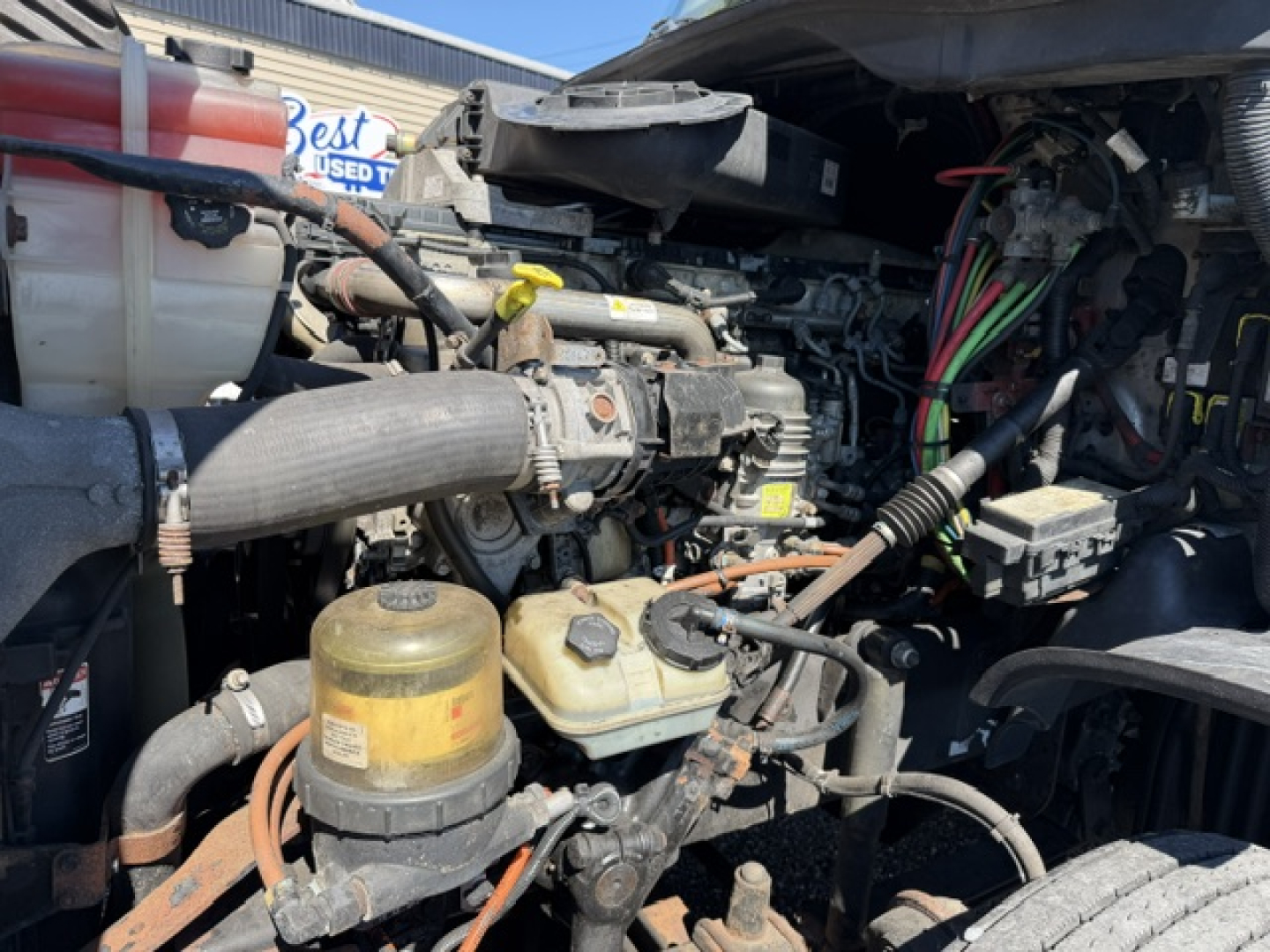 Freightliner Cascadia engine bay showing engine components and wiring harnesses.