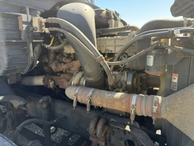Freightliner Cascadia engine bay showing hoses, intake, and radiator area.
