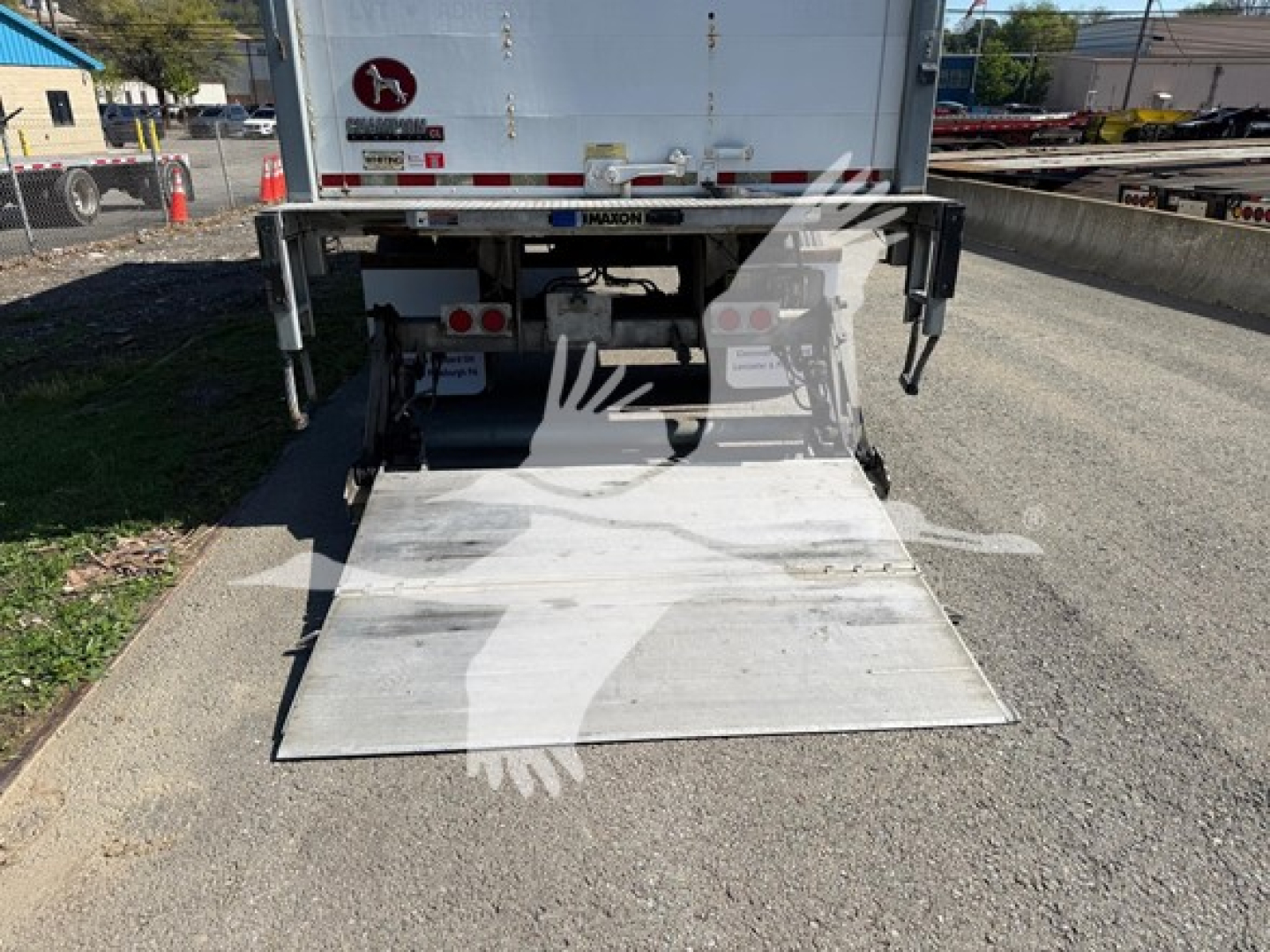Rear view of a 2018 Great Dane Pup van trailer with a portable aluminum ramp extended to ground, showing tail lights, rear bumper, and reflective decals.