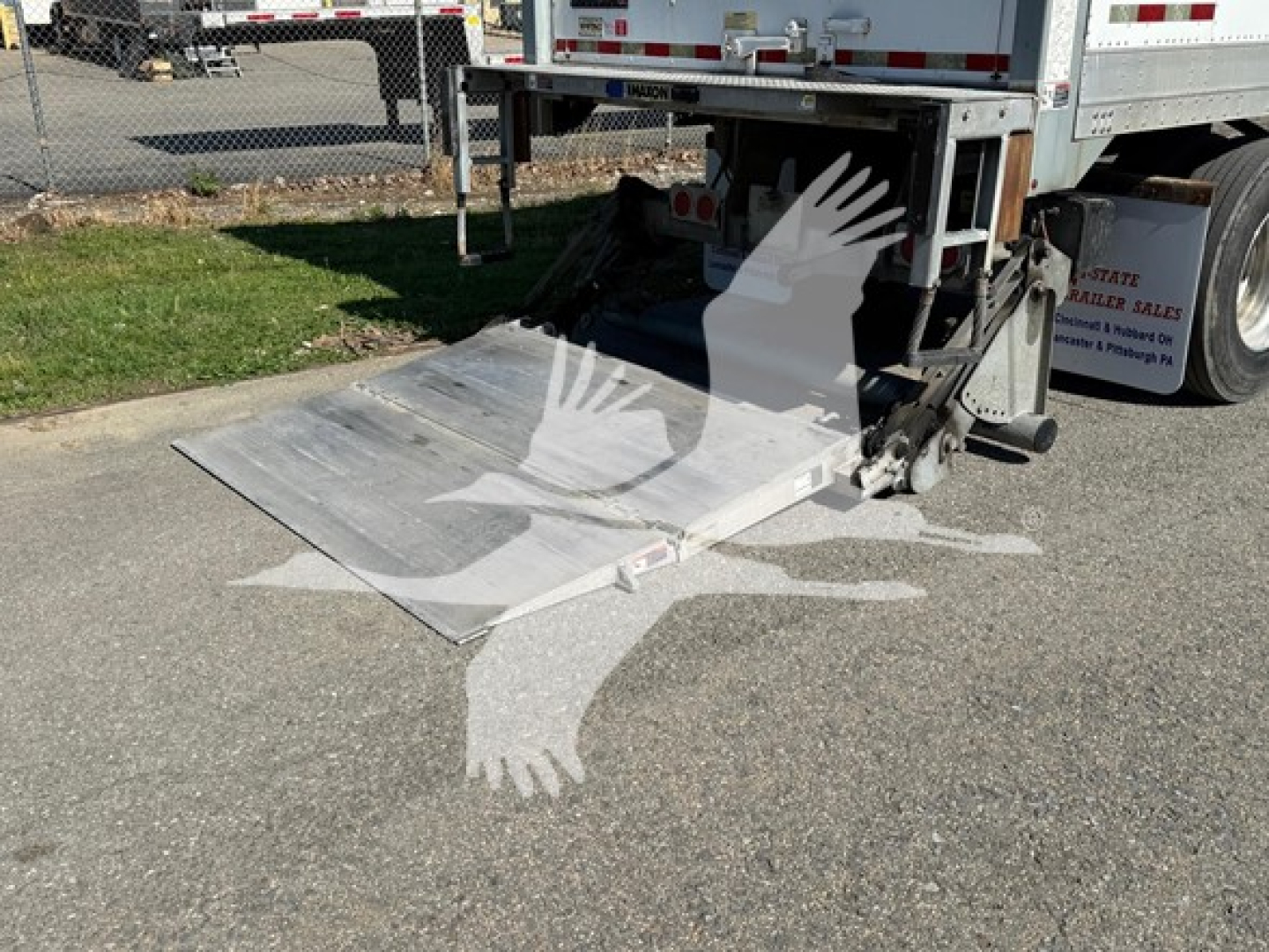 Wheelchair-accessible Great Dane Pup trailer with a lowered aluminum ramp extended from the rear, showing a close-up of the ramp and subframe.