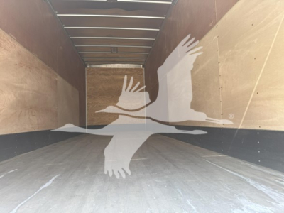 Trailer interior showing empty cargo space with wooden sidewalls and a flat metal floor.
