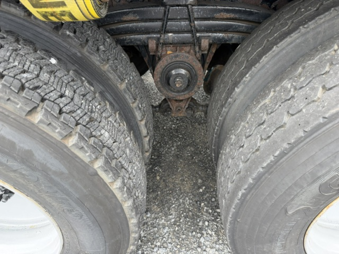 Dual rear dual tires and leaf spring suspension on a Volvo VHD truck chassis, center hanger pad visible between tires.