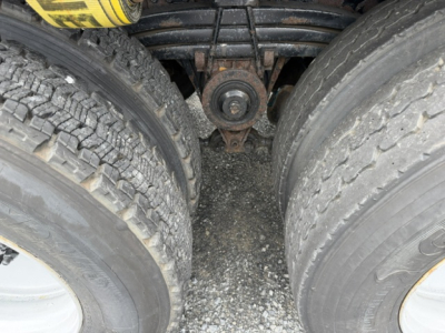 Dual rear dual tires and leaf spring suspension on a Volvo VHD truck chassis, center hanger pad visible between tires.