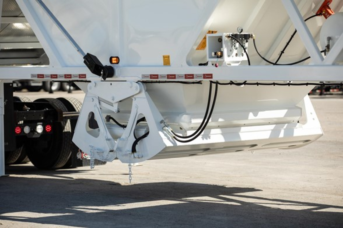 Dump trailer bottom; legs and hydraulic switchgate area visible with hoist mechanism and wiring.