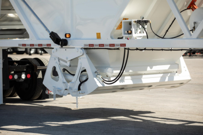 Dump trailer rear view showing suspension and hydraulic lines on a white Ranco wet sand switchgate bottom dump.