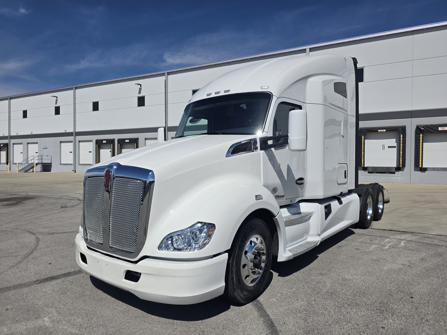 Kenworth T680 2022 conventional sleeper truck in white, front-left view with chrome grille and headlights.