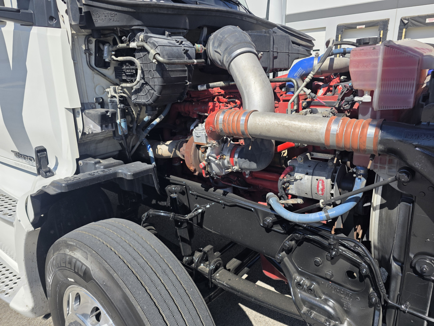Kenworth T680 engine bay view showing turbo intake, hoses, and components.