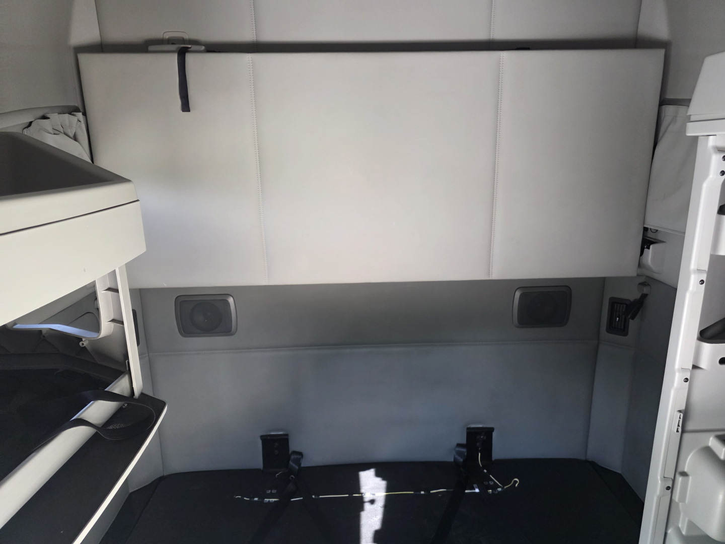 Truck interior rear cargo area of a 2022 Kenworth T680 showing side panels and floor with mounting brackets.