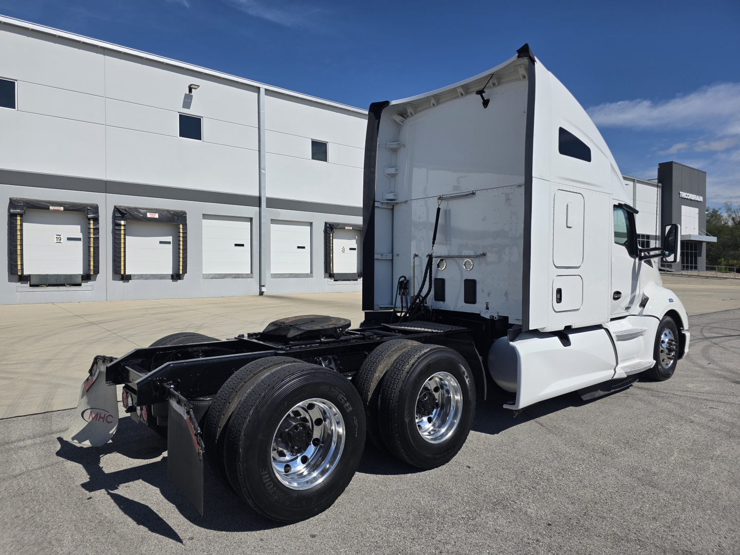 Kenworth T680 rear/side view showing tractor chassis with dual rear axles and sleeper cab, white exterior, no trailer attached.