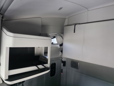 Kenworth T680 sleeper cab interior and bunk area showing upper compartments and side panels.