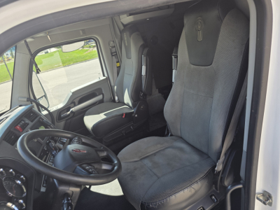 Kenworth T680 truck cab interior showing steering wheel, driver's seat, and dashboard.