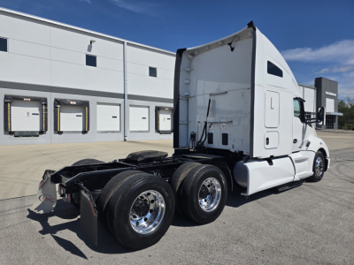 Kenworth T680 rear/side view showing tractor chassis with dual rear axles and sleeper cab, white exterior, no trailer attached.