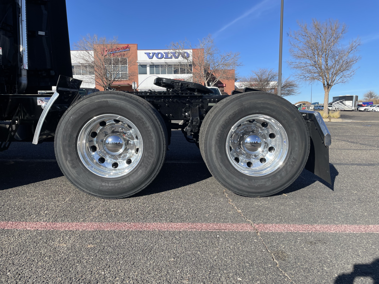 Dual rear drive wheels of a Mack PR64T76H tractor showing chrome rims and tires.