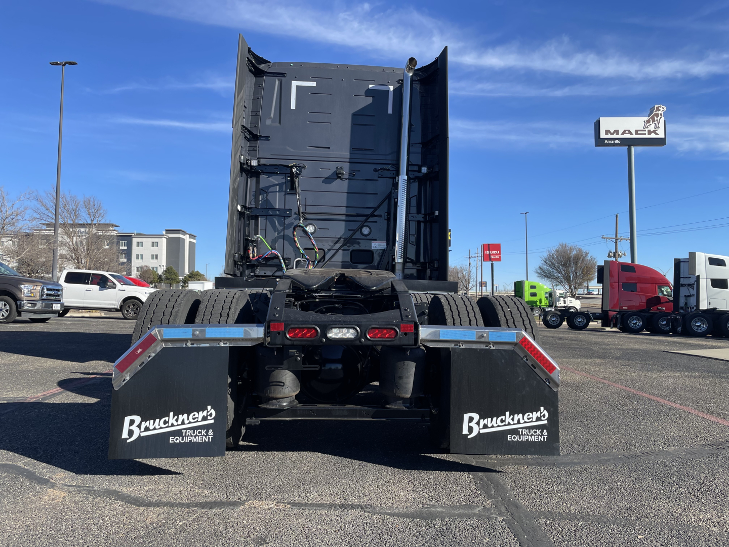 Mack PR64T76H truck chassis rear view showing mud flaps with Bruckner's Equipment branding and tall sleeper cab in distance.