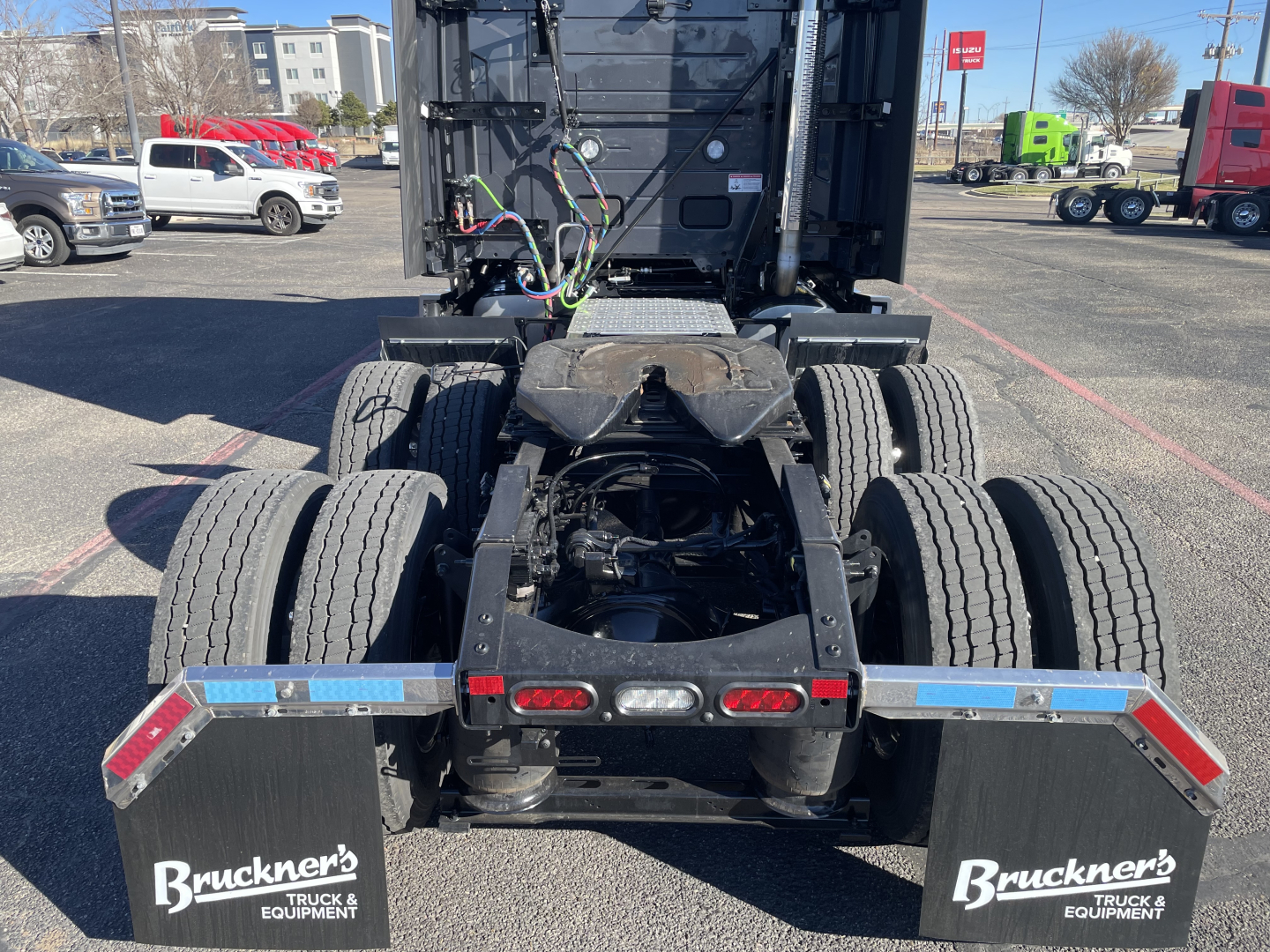 Mack PR64T76H tractor rear view showing fifth-wheel area, dual rear axles, and Brackner's Truck & Bus bed guards with reflective strips.