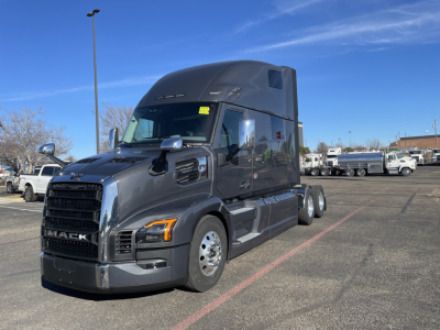 Mack PR64T76H cab in sleeper configuration in a dealership lot; front grille, headlights, side mirrors, and dual rear axles visible.