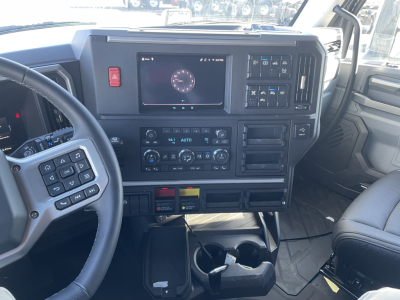 Dashboard of a 2026 Mack PR64T76H truck showing steering wheel, digital display, climate controls, and center console with multiple buttons.