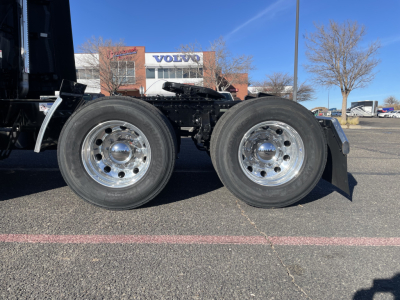Dual rear drive wheels of a Mack PR64T76H tractor showing chrome rims and tires.