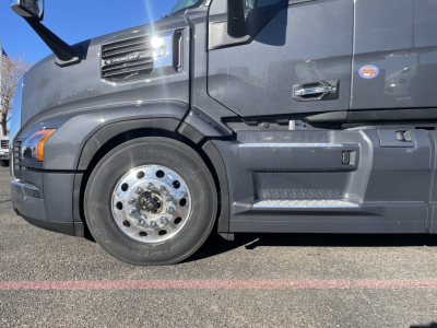 Truck side view showing front wheel and cab of a 2026 Mack PR64T76H conventional sleeper.