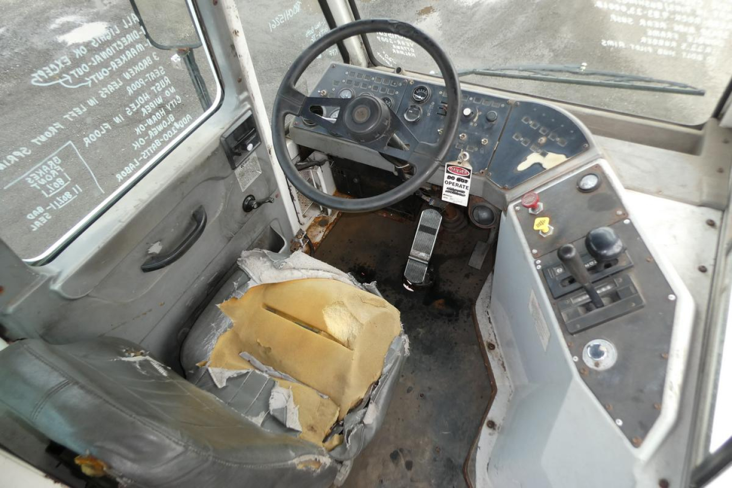 Cab interior of a 2007 Ottawa 4x2 truck showing steering wheel, dashboard, and worn seat with torn upholstery.
