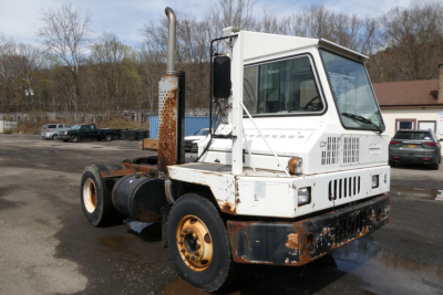 Truck cab and chassis showing white and rusted Ottawa 4x2 yard truck with tall exhaust stack and weathered bumper.