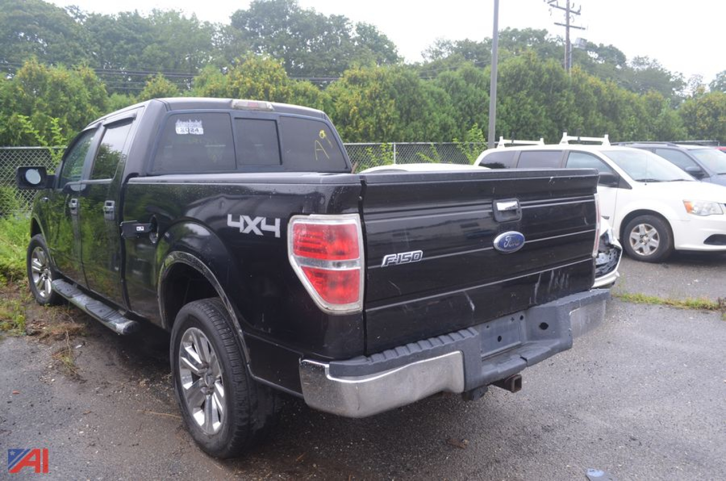 Ford F-150 crew cab pickup truck rear view showing 4x4 badge and tailgate with P-150 emblem in a parking lot.